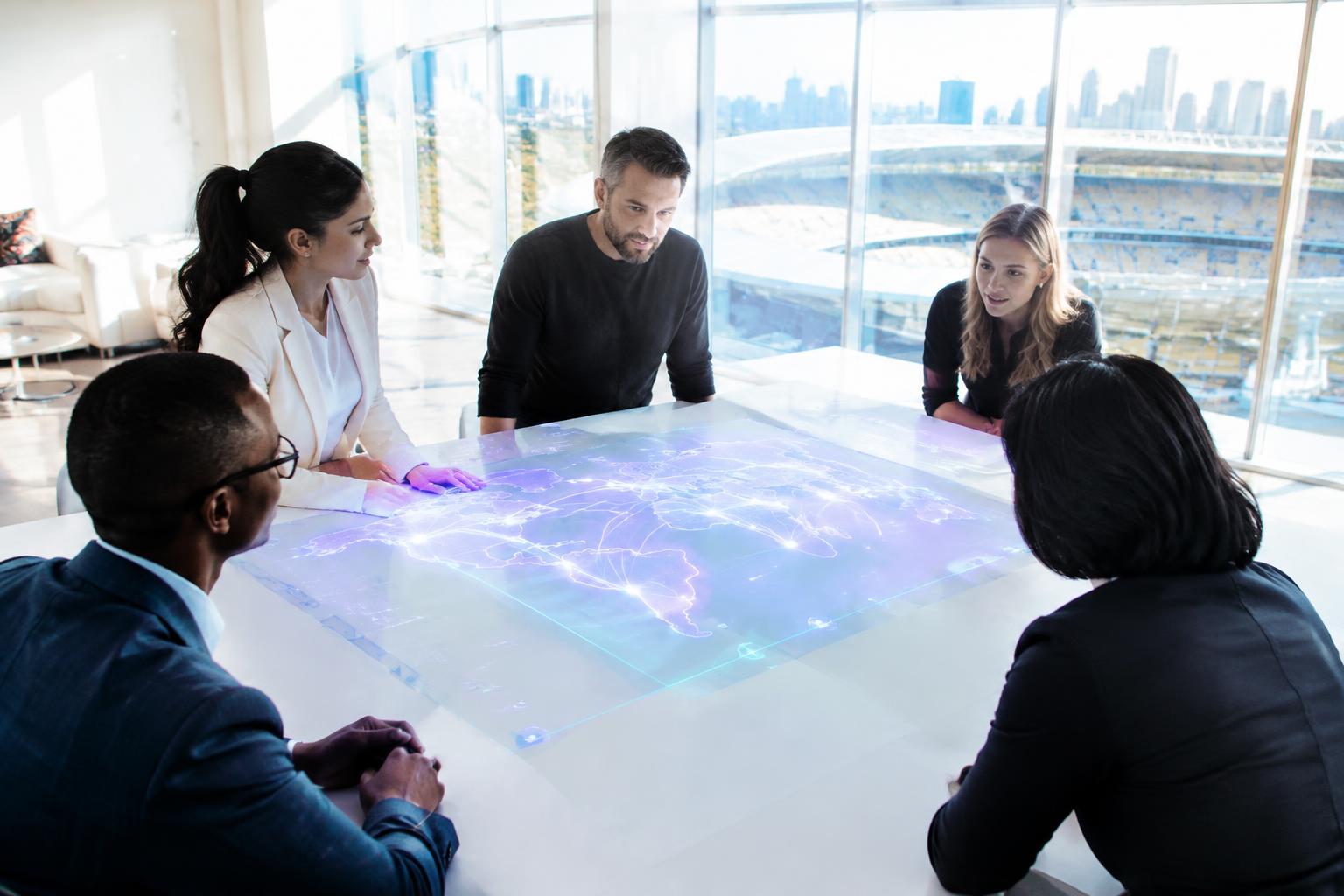 Leadership team around a table showing a glowing map of connected venues
